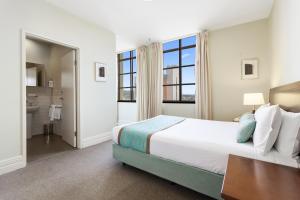 a bedroom with a large bed and a bathroom at Launceston Central Apartment Hotel Official in Launceston +22 photos