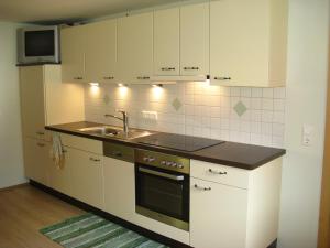 a kitchen with white cabinets and a sink at Ortnerhof in Millstatt