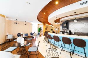 a restaurant with a bar with chairs and tables at Ibis Hong Kong Central & Sheung Wan in Hong Kong