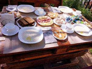 a wooden table with white plates and food on it at L'a Dacha in Tamga