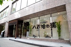 a store front of a building with writing on the window at Natural Hot Spring Yaoji Hakata Hotel in Fukuoka
