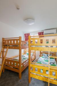 a room with three bunk beds in a room at Stay Asahikawa Koto in Asahikawa