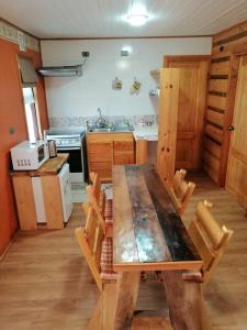 une cuisine avec une table en bois et des chaises. dans l'établissement Apart Hotel Claro de Luna, à Frutillar