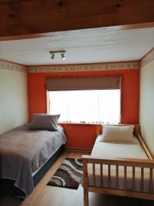 een slaapkamer met oranje muren en een bed en een raam bij Apart Hotel Claro de Luna in Frutillar
