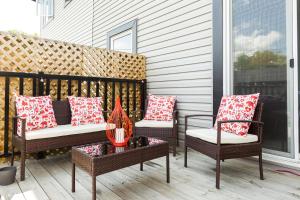 2 sillas y una mesa en un porche con almohadas en Mountain House, en Edmonton
