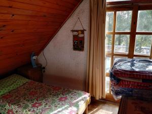 ein Schlafzimmer mit einem Bett und einem Fenster in einer Hütte in der Unterkunft Lago Merin in Lago Merin