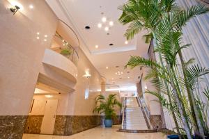 a hallway with stairs and palm trees in a building at Natural Hot Spring Yaoji Hakata Hotel in Fukuoka