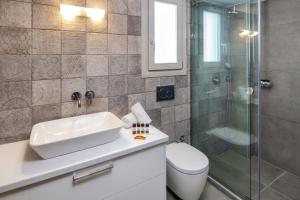 un bagno con lavandino, doccia e WC di Elea Hub a Oia