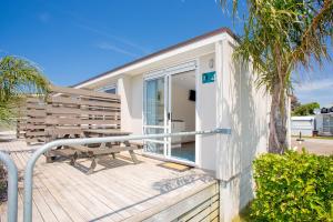 una casa con un banco en una cubierta en Tasman Holiday Parks - Beachaven, en Waihi Beach