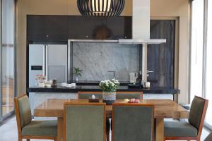 a kitchen with a wooden table and chairs at The Kharma Villas Yogyakarta in Yogyakarta