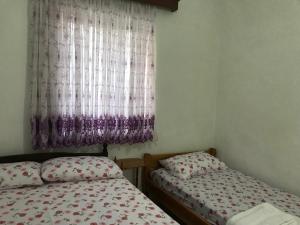 two twin beds in a room with a window at Private Apartment Jolanda in Sarande in Sarandë