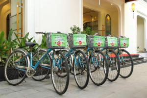 Uptown Hoi An Hotel & Spa في هوي ان: أربعة دراجات متوقفة على التوالي أمام مبنى