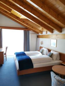 サースフェーにあるホテル アルペンペルレの木製の天井の客室で、ベッドルーム1室(大型ベッド1台付)