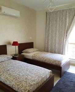 1 Schlafzimmer mit 2 Betten und einem Fenster in der Unterkunft Hayat Al-Rehab Apartment in Kairo
