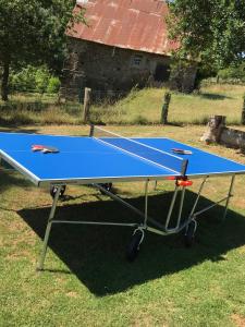 a ping pong table sitting on top of a field at La Cahudiere in Saint-Martin-Landelles