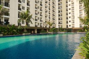 a large swimming pool in front of a building at Modern Studio Apartment at Cinere Resort By Travelio in Depok