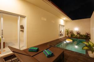 a living room with a pool in the middle of a house at Villa Julie & Villa Sydney, Seminyak - 2 Bedroom Modern Pool Villas! in Seminyak