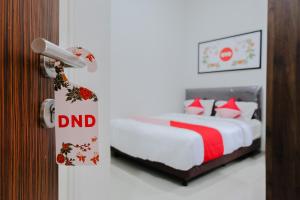 מיטה או מיטות בחדר ב-Super OYO 1038 Embun Pagi Syariah Residence