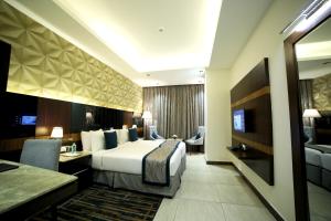 バンガロールにあるRg Royal Hotelのベッドとテレビが備わるホテルルームです。