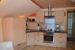 uma cozinha com armários de madeira e um forno com placa de fogão em Appartement Tiefenbrunn em Auffach