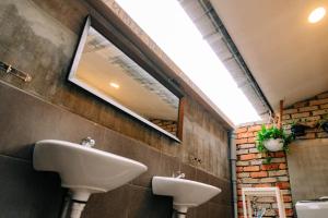 a bathroom with two sinks and a mirror on the wall at Rembulan Langkawi Guesthouse in Pantai Cenang