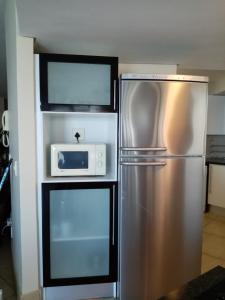a kitchen with a stainless steel refrigerator and a microwave at Beautiful Ocean Views in Strand