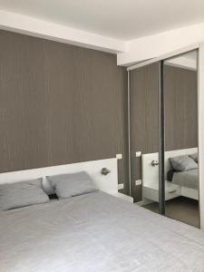 ママイアにあるLe Reve Apartment Mamaia Nordのベッドルーム(ベッド1台、鏡付)