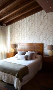 ein Schlafzimmer mit einem großen Bett und zwei Lampen in der Unterkunft CASA RURAL VERSOS in San Martín del Castañar + 43 Fotos