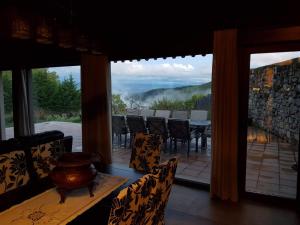 ein Esszimmer mit Tisch und Stühlen und einem großen Fenster in der Unterkunft CASA RURAL VERSOS in San Martín del Castañar