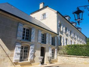 - un bâtiment avec des fenêtres blanches et une lumière de rue dans l'établissement Moulin Royale, à Saint-Etienne-Roilaye