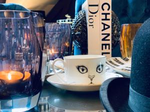 un tavolo con una tazza con la faccia da gatto di Moulin Royale a Saint-Etienne-Roilaye