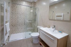 een badkamer met een toilet, een wastafel en een douche bij La Fontina de Luarca in Luarca