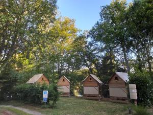 a row of houses in a field with trees at L'Aquarelle - Camping in La Souterraine