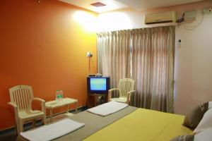 a hospital room with two beds and a television at Krishna Villa in Badami