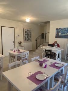 un comedor con mesas y sillas y una escalera en Il Lauro, en San Costanzo