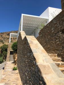 a stone wall in front of a house at Theros apartments 2 in Mylopotas