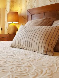 a bedroom with a bed and a lamp and a bedspread at CASA RURAL VERSOS in San Martín del Castañar