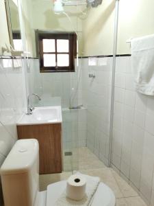 y baño con aseo, lavabo y ducha. en Pousada Duas Quedas, en Campos do Jordão
