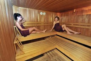 zwei Frauen sitzen in einer Sauna in der Unterkunft Hotel Wenzels Hof in Zwethau