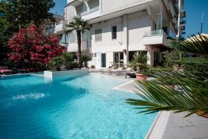 a swimming pool in front of a building at SI Rimini Hotel in Rimini