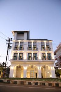 a white building with balconies on a street at Villa Donna in Dona Paula