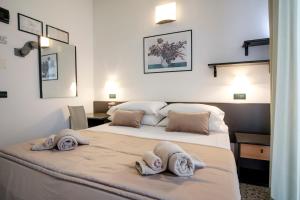 Dos camas en una habitación con toallas. en SI Rimini Hotel, en Rímini