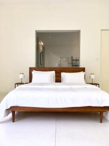 a bedroom with a large bed with white sheets at UYANA Boutique Sanctuary ADULTS ONLY in Ahangama