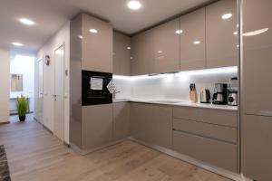 una cocina con armarios marrones y blancos y suelos de madera. en Central Lootsi Penthouse en Tallin