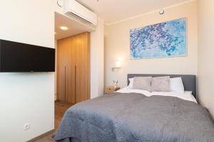um quarto com uma cama e uma televisão de ecrã plano em Central Lootsi Penthouse em Talin