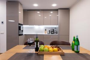 a table with a tray of fruit and wine bottles at Central Lootsi Penthouse in Tallinn