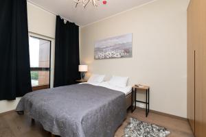 a bedroom with a bed and a window at Central Lootsi Penthouse in Tallinn