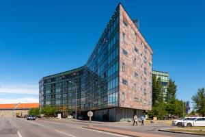 a tall glass building on the corner of a street at Central Lootsi Penthouse in Tallinn
