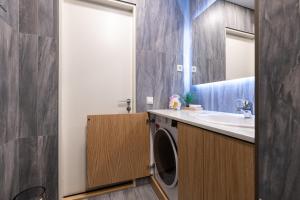 a bathroom with a washing machine and a sink at Central Lootsi Penthouse in Tallinn +73 photos