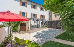 einen roten Regenschirm im Hof eines Hauses in der Unterkunft Apartment ire' in Karšete